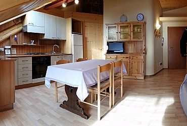 Appartamento a Predazzo. <p>L'ampio soggiorno è dotato di cucina completa (fuochi, forno, cappa, microonde, frigo e freezer); il divano letto è matrimoniale.
<p>A richiesta, nel soggiorno è possibile alloggiare un 5° letto richiudibile. <p><p>The living room.
The window with three side glasses, has a panoramic view of the Lagorai and Latemar mountains