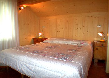 Appartamento a Predazzo. <p>La camera da letto, dispone di un armadio, una specchiera ed una cassettiera.<p> <p> The bedroom.
Comfortable and furnished in a warm mountain style
