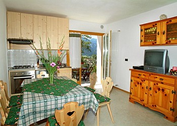 Appartamento a Predazzo. Soggiorno con angolo cottura e due poltrone letto.