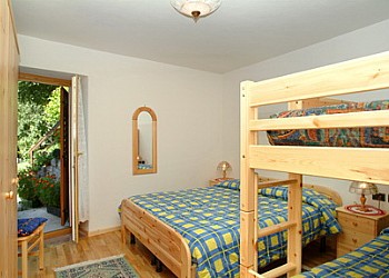 Appartamento a Predazzo. Camera matrimoniale con grande letto a castello (2,10 x 1,10 metri).