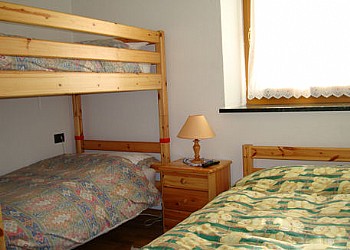 Appartamento a Predazzo. Camera con possibilita di 1 letto matrimoniale o letto a castello in legno massiccio (due letti singoli grandi 2,10 x 1,10) + 1 letto o 2 singoli.