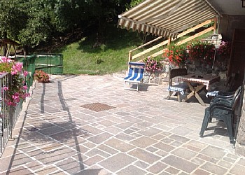 Appartamento a Predazzo. Piazzale con tavolo esterno per un' appartamento con lettino prendi sole.