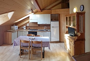 Appartamento a Predazzo. <p>La cucina con il grande tavolo allungabile, dove possono mangiare comodamente 6 persone
