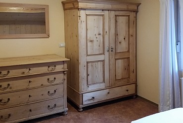 Appartamento a Predazzo. <p>I mobili e l'arredamento della camera da letto sono realizzati con il legno di abete e di larice della Valle di Fiemme.